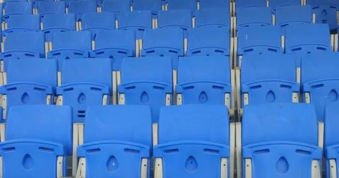 Neatly Arranged Rows of Empty Blue Stadium Chairs Awaiting Spectators at a .. Stock Photos