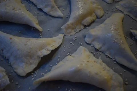 Neatly Arranged Triangular Pastries on Baking Tray Foto stock