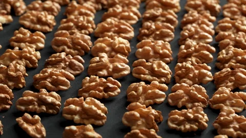 Neatly Arranged Walnut Kernels In Rows Rotating Black Background Video stock 332525278