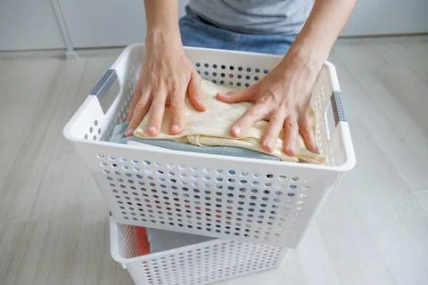 Neatly folded clean laundry placed in a basket after washing. People organize Stock Photos