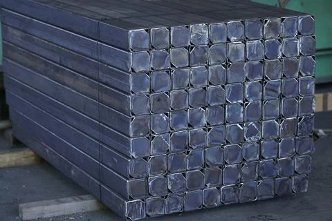 A neatly stacked stack of square metal profiles. 스톡 사진
