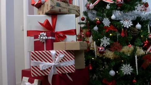 Neatly wrapped gift boxes beneath the contemporary Christmas tree in a home Stock Footage 288810511