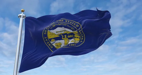Nebraska flag with flagpole waving in rolling clouds looping, 4K Perfect Loop 库存影片 280926040