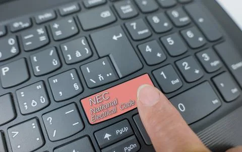 NEC-national electrical code key on a gray keyboard. Finger pressing key Stock Photos
