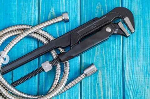 Necessary set of tools and hose for master plumber on blue wooden boards Stock Photos