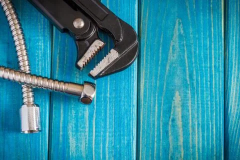 Necessary set of tools and hose for master plumber on blue wooden boards Stock Photos