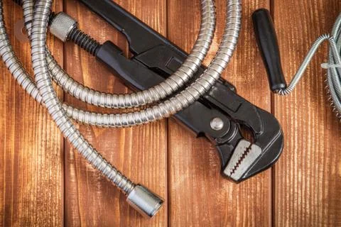 Necessary set of tools and hose for plumbers on vintage wooden boards Stock Photos