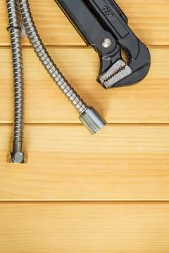Necessary set of tools and hoses for plumbers on wooden boards Stock Photos