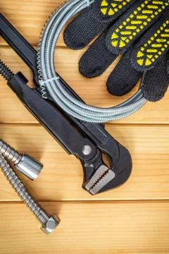Necessary set of tools and hoses for plumbers on wooden boards Stock Photos