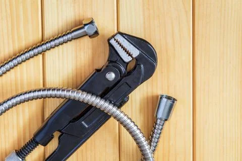 Necessary set of tools and hoses for master plumber on wooden boards Stock Photos
