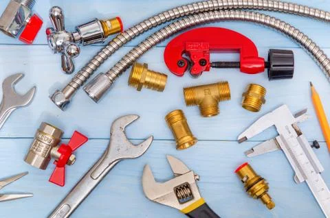 Necessary set of tools and spare parts for plumbers on blue wooden background Stock Photos
