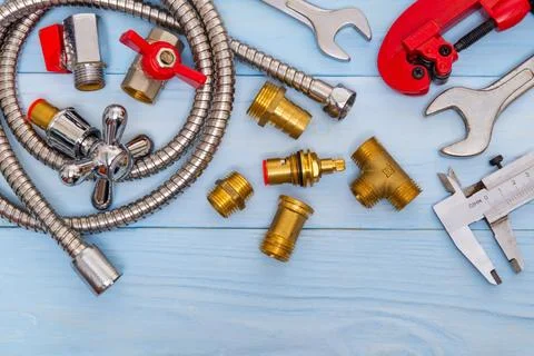 Necessary set of tools and spare parts for plumbers on blue wooden background Stock Photos
