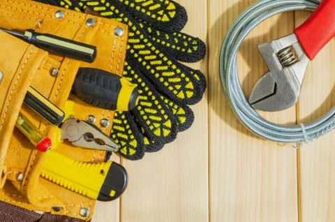 Necessary set of tools in the bag for plumbers on a wooden background. Stock Photos