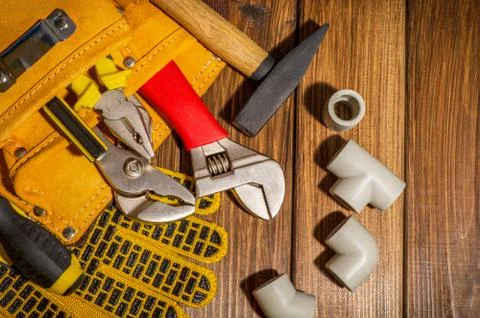 Necessary set of tools in the bag for plumbers on a vintage wooden background Stock Photos