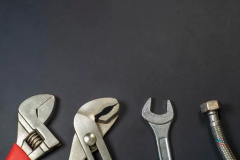 Necessary set of tools for plumbers on a black background. Stock Photos