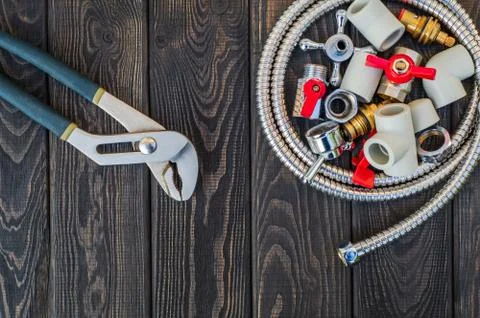 Necessary set of tools for plumbers on black vintage wooden background Stock Photos
