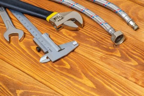Necessary set of tools for plumbers on vintage wooden boards with space for a Stock Photos