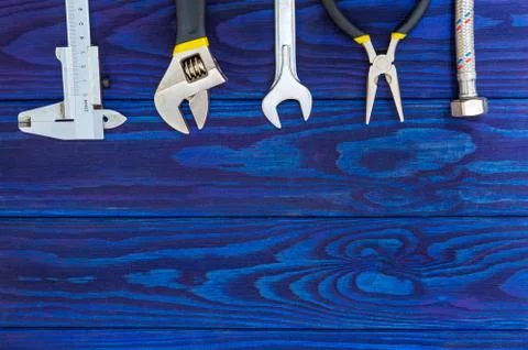 Necessary set of tools for plumbers on wooden blue boards with space for adve Stock Photos