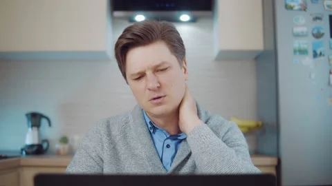 Neck hurts. A man working at a computer is experiencing fatigue and neck pain Stock Footage 148823072
