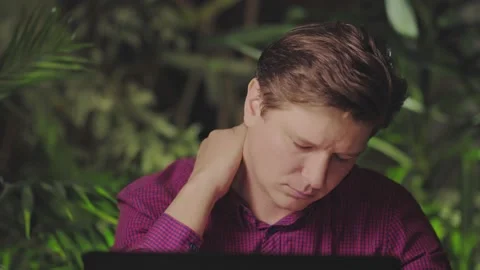 Neck hurts. A man working at a computer is experiencing fatigue and neck pain Stock Footage 150166511