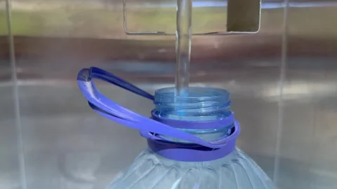 The neck of a plastic bottle into which clean water is poured for drinking. Stock Footage 240804957
