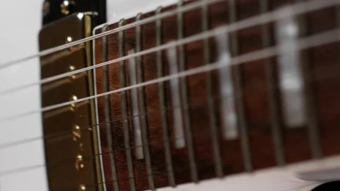 Neck, strings and gold pickups on a white guitar Stock Footage 155638064
