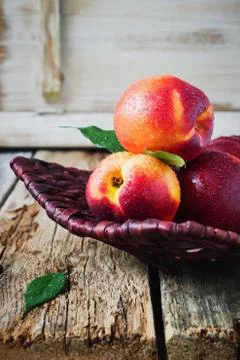 Nectarine in a wicker plate. Stock Photos