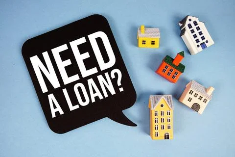 Need A Loan? text with house models on blue background Stock Photos