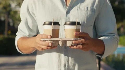 Need more coffee today. Close up cropped man holding in hand holder two takeaway Stock-Footage 218363464