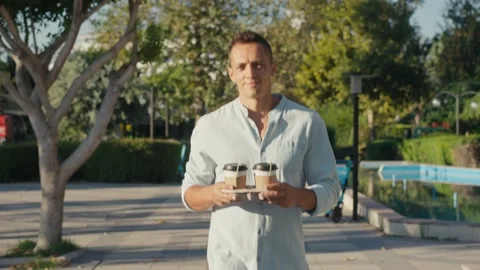 Need more coffee today. Close up cropped man holding in hand holder two takeaway Stock Footage 218582863