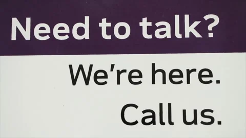 Need to talk were here call us sign in white and black print on purple and white Stock Footage 246611816