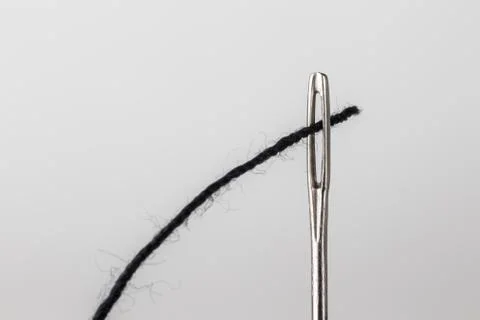 Needle and black thread close up Stock Photos