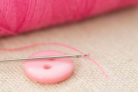 A needle and thread is on the button Stock Photos