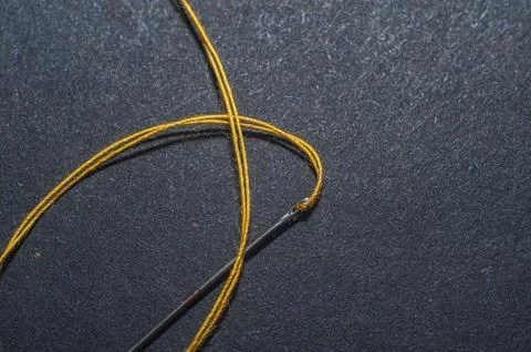 Needle and thread for needlework black background. Stock Photos