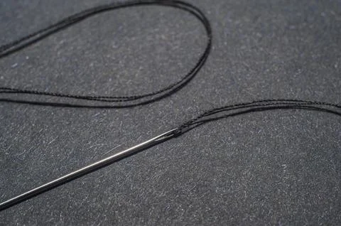 Needle and thread for needlework black background. Stock Photos