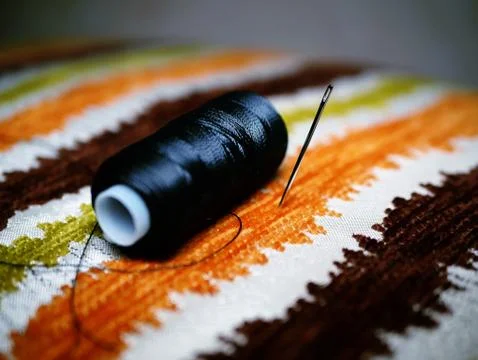 Needle and a thread over colorful background Stock Photos