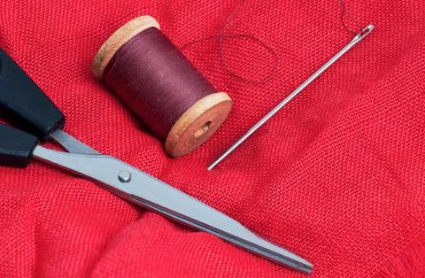 Needle and thread on a red background Stock Photos