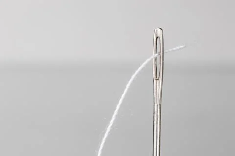 Needle and white thread close up Stock Photos