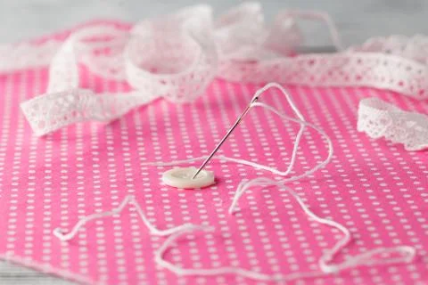 Needle an? button pinned on polka dot cloth Stock Photos