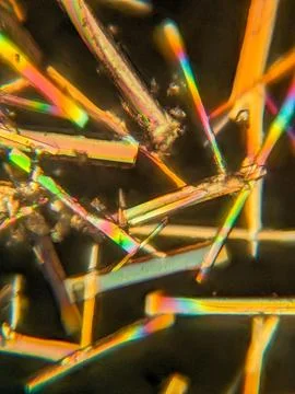 Needle-like crystals under polarized microscope showing vivid birefringence 스톡 사진