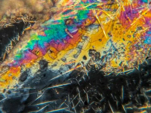 Needle-like crystals under polarized microscope showing vivid birefringence 스톡 사진