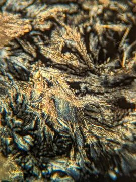 Needle-like crystals under polarized microscope showing vivid birefringence 스톡 사진