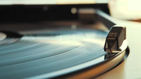 Needle is dropping on a vinyl record spinning on a turntable Stock Footage 292924629