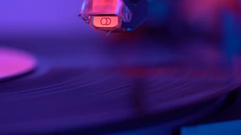 The needle drops on the disc, macro. Vinyl disc turning on retro record player. Stock-Footage 69847499