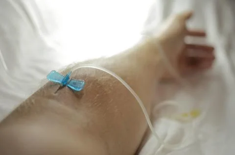 The needle is inserted into a vein in the arm. Dropper for treatment Stock Photos