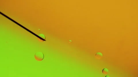 The needle makes drops of different sizes on a yellow-green gradient surface Stockbeeldmateriaal 303059168