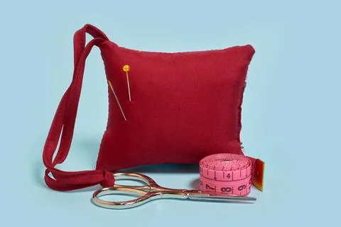 A needle pad, scissors and a tailor 's meter on a blue background Stock Photos