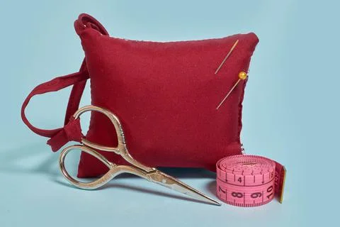 A needle pad, scissors and a tailor 's meter on a blue background Stock Photos