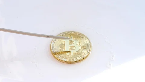 Needle popping a gold BTC cryptocurrency coin soap bitcoin bubble popping  Stock Footage 85756361