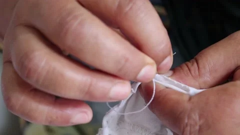 Needle of a sewing by hand makes a thread stitch. Stock Footage 157571146
